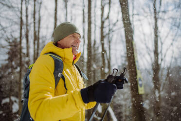 Älterer Mann bewundert die Natur beim Skilanglauf im Wald. - HPIF11295