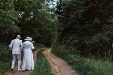 Rückansicht eines älteren Paares bei der Hochzeitsfotografie in einem Wald an einem Sommertag. - HPIF11415
