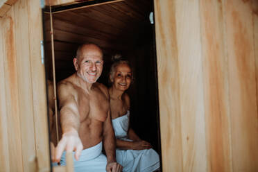 Ein älteres Paar genießt die gemeinsame Zeit in der Sauna, entspannt sich, genießt das Spa und das Konzept der gesunden Lebensweise. - HPIF11454