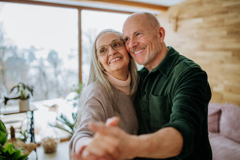 Senior couple in love dancing together in their nice modern living room. - HPIF11527