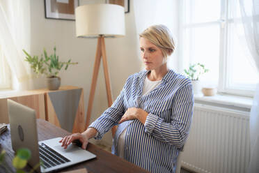 Eine schwangere Frau im Home Office. - HPIF11631