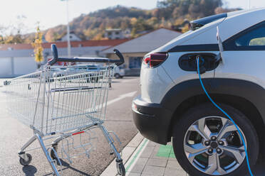 Modernes Laden von Elektroautos auf einem Supermarktparkplatz. - HPIF11695