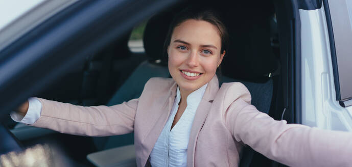 Aufgeregte junge Frau, die in ihrem Auto sitzt und sich auf eine Fahrt vorbereitet. - HPIF11731