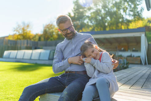 Vater mit seiner kleinen Tochter im Garten an einem sonnigen Herbsttag. - HPIF11741