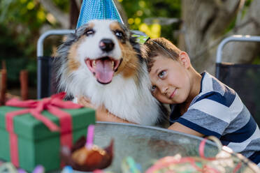 Kleiner Junge und sein Hund bei einer Geburtstagsfeier. - HPIF11807