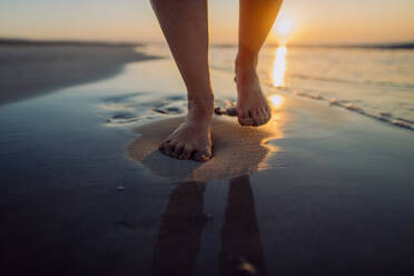 Frau, die bei Sonnenuntergang am Strand spazieren geht, Nahaufnahme der Füße. - HPIF12008
