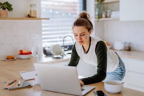 Junge Frau mit Homeoffice in einer Küche. - HPIF12049