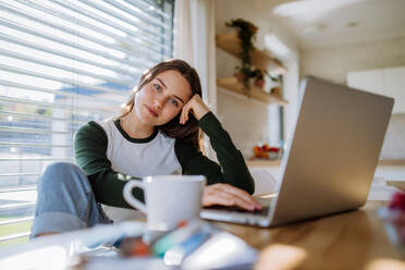 Portrait of a bored woman with laptop, homeoffice concept. - HPIF12070