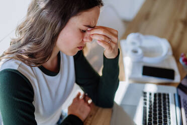 Portrait of a tired woman with laptop, homeoffice concept. - HPIF12080