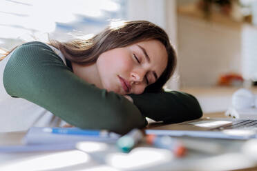 Young woman fall asleep at the table during learning. stock photo