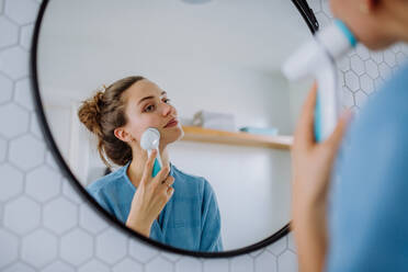 Junge Frau, die sich um ihre Gesichtshaut kümmert, Konzept der morgendlichen Schönheitsroutine. - HPIF12133