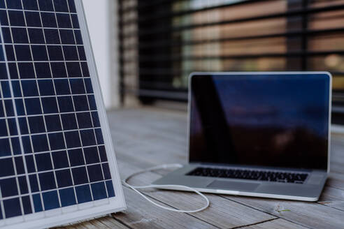 Nahaufnahme des Laptops, der durch das Solarpanel aufgeladen wird. - HPIF12156