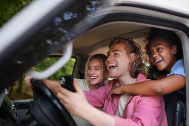 Multirassische junge Freunde, die zusammen in einem Auto reisen und Spaß haben - Sommerurlaub, Ferien, Reisen, Roadtrip und Menschen Konzept. - HPIF12192
