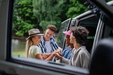 Multirassische junge Freunde, die zusammen in einem Auto reisen, am Auto stehen und lächeln - Sommerurlaub, Ferien, Reisen, Road Trip und Menschen Konzept. - HPIF12197