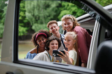 Eine bunt gemischte Gruppe von Freunden auf einem Sommer-Roadtrip hält ihre Erinnerungen mit einem Selfie fest - und feiert damit Reisen, Freundschaft und Abenteuer - HPIF12198