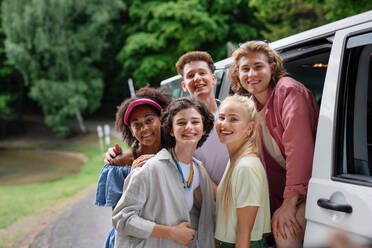 Eine multirassische junge Freunde reisen zusammen mit dem Auto, Blick auf die Kamera und lächelnd - Sommerurlaub, Urlaub, Reisen, Road Trip und Menschen Konzept. - HPIF12199