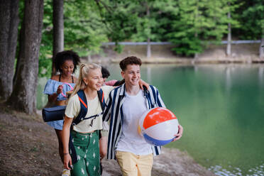 Eine Gruppe junger Freunde auf einem Campingausflug in der Nähe eines Sees im Sommer. - HPIF12214
