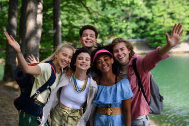 Porträt einer Gruppe junger Freunde auf einem Campingausflug in der Nähe eines Sees im Sommer. - HPIF12217