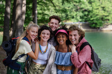 Porträt einer Gruppe junger Freunde auf einem Campingausflug in der Nähe eines Sees im Sommer. - HPIF12218