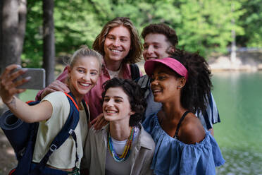 Eine Gruppe junger Freunde auf einem Campingausflug in der Nähe eines Sees im Sommer. - HPIF12220