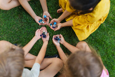 Draufsicht auf spielende und sich unterhaltende Kinder in einem Stadtpark, während eines Sommertages. - HPIF12312