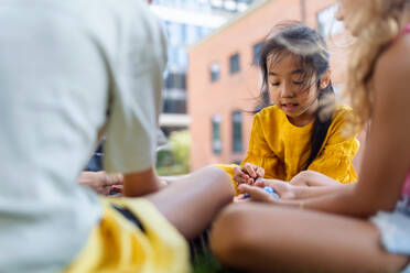 Happy kids playing and talking together in s city park, during summer day. - HPIF12314