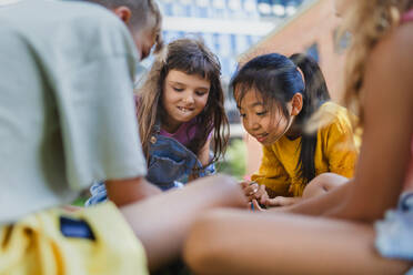 Happy kids playing and talking together in s city park, during summer day. - HPIF12315