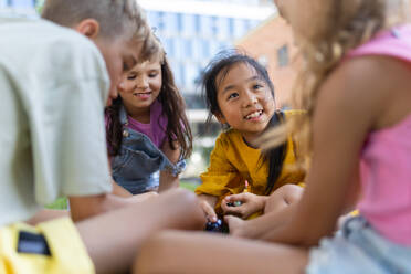 Happy kids playing and talking together in s city park, during summer day. - HPIF12316