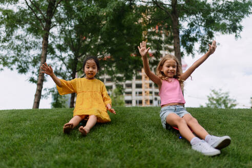 Asiatisches Mädchen versucht, mit ihrem Freund in einem Stadtpark Skateboarding, aktive Kinder Konzept. - HPIF12339