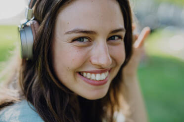 Portrait of young woman listening the music trough headphones. - HPIF12498