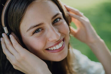 Portrait of young woman listening the music trough headphones. - HPIF12500