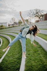 Happy young woman feeling free, posing during walking in a city. - HPIF12509