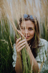 Porträt einer jungen schönen Frau, die im Gras posiert. - HPIF12514