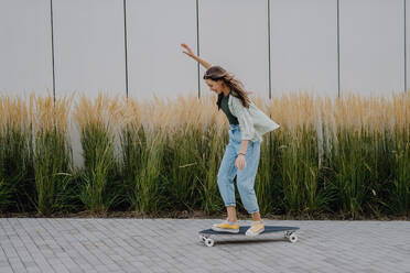 Junge Frau auf einem Skateboard in der Stadt, Jugendkultur und Pendlerkonzept. - HPIF12515