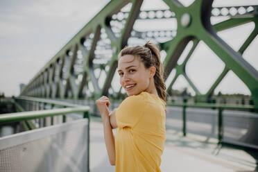 Young woman doing stretching in a city, preparing for run, healthy lifestyle and sport concept. - HPIF12615