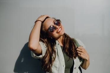 Portrait of happy young woman outdoor with a backpack and sunglasses. - HPIF12626