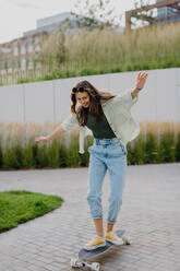 Young woman ridding a skateboard in a city. Youth culture and commuting concept. - HPIF12637