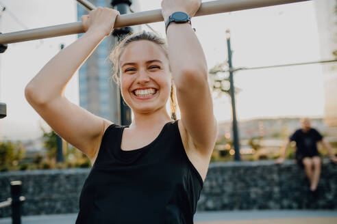 Happy young woman doing exercises at outdoor work-out city park. - HPIF12646