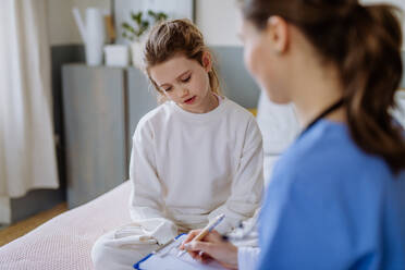 Junge Ärztin, die sich um ein kleines Mädchen in einem Krankenhauszimmer kümmert. - HPIF12650