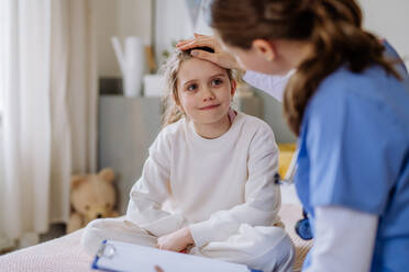 Junge Ärztin, die sich um ein kleines Mädchen in einem Krankenhauszimmer kümmert. - HPIF12653