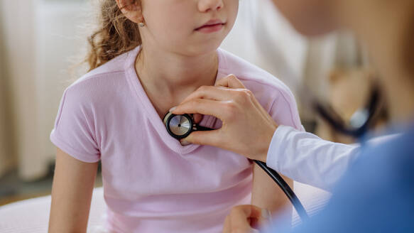 Junge Ärztin, die sich um ein kleines Mädchen in einem Krankenhauszimmer kümmert. - HPIF12662