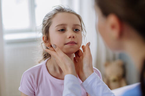 Young doctor taking care of little girl in a hospital room. - HPIF12663