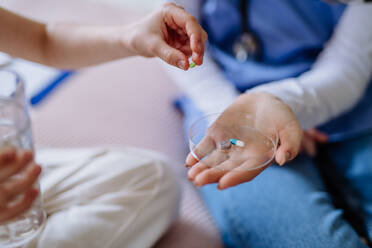 Nahaufnahme einer Krankenschwester, die einem Patienten Tabletten verabreicht. - HPIF12669