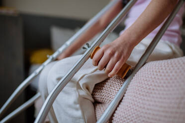 Mid section of little girl with broken leg sitting on bed. - HPIF12683