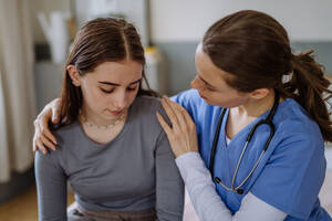 Junge Krankenschwester, die sich um ein junges Mädchen kümmert und sie tröstet. - HPIF12693