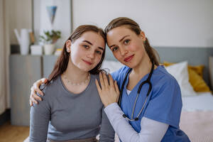 Junge Krankenschwester, die sich um ein junges Mädchen kümmert und sie tröstet. - HPIF12697