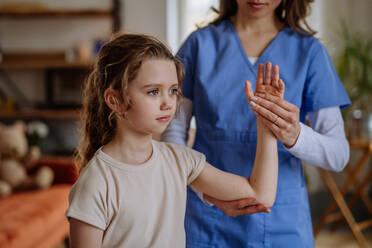 Kleines Mädchen beim Training mit einem Physiotherapeuten. - HPIF12717