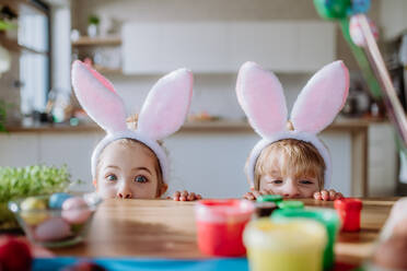 Kleine Geschwister genießen die Osterzeit gemeinsam in ihrem Haus. - HPIF12751