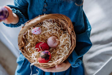 Top view of little girl holding basket with the easter eggs. - HPIF12763