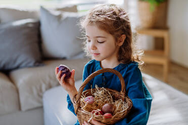 Portrait of little girl holding basket with the easter eggs. - HPIF12764
